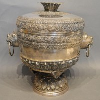 An Indian White Metal Large Covered Vase on Stand, the shaped cover above mask ring handles and circular pedestal stand Hammer £1,100